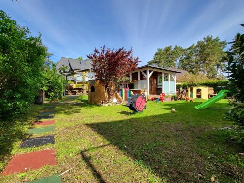 a yard with a house and a playground at Ferienhaus Strandstr 29 in Kolpinsee