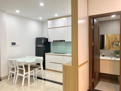 a kitchen with a table and a black refrigerator at Sweet Dreams Homestay Westlake Hanoi in Hanoi