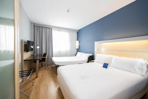 a hotel room with a large white bed and a desk at Holiday Inn Express Barcelona City 22@, an IHG Hotel in Barcelona