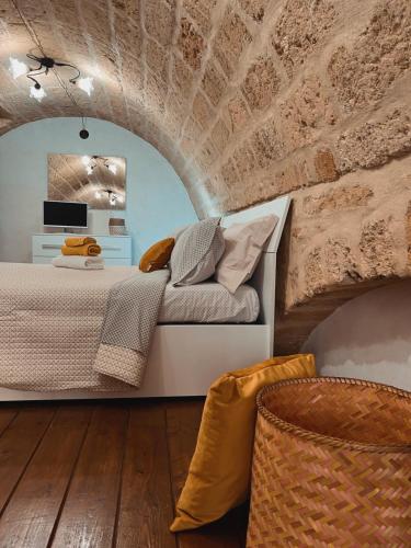 a bedroom with a bed and a brick wall at Suite San Pietro in Galatina