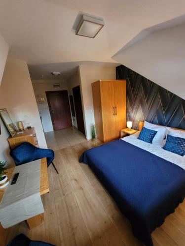 ein Schlafzimmer mit einem großen blauen Bett und einem Sofa in der Unterkunft APARTAMENTY TR 11 Apartament nr 5 in Olsztyn