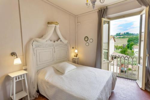 ein Schlafzimmer mit einem weißen Bett und einem großen Fenster in der Unterkunft Il Piccolo Verde in Terranuova Bracciolini