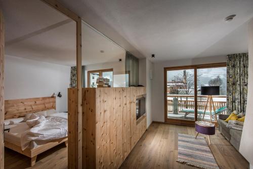 a bedroom with a bed and a large window at Naturhotel Saalerwirt in San Lorenzo di Sebato