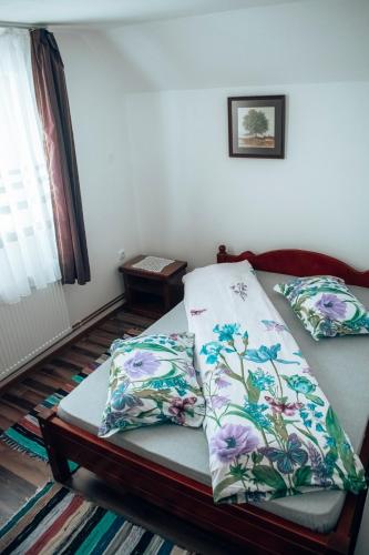 a bed with two pillows on it in a room at Casa Ianis in Arieşeni