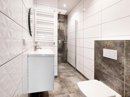 La salle de bains blanche est pourvue d'un lavabo et de toilettes. dans l'établissement Herta House, à Dorotowo