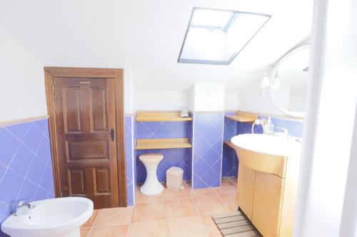 un bagno blu e bianco con lavandino e WC di Casa Fina Espeja (Salamanca) a Espeja
