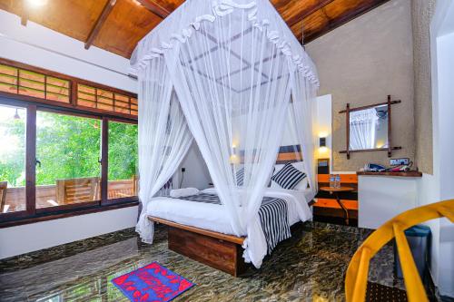 a bedroom with a canopy bed with mosquito net at Royal Mount Ella in Ella