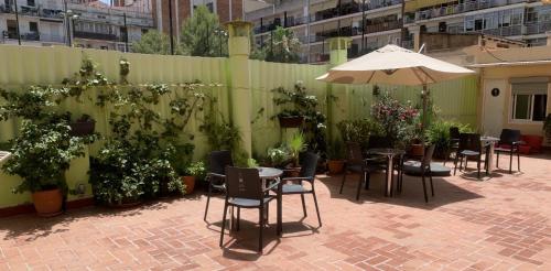 a patio with tables and chairs and an umbrella at Paraiso Hostel in Barcelona