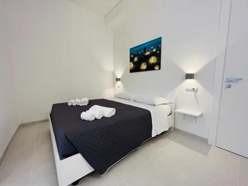 a white bedroom with a bed with towels on it at Pirro’s rooms in Peschici