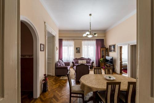 sala de estar con mesa, sillas y sofá en Apartment Panorama Central, en Novi Sad