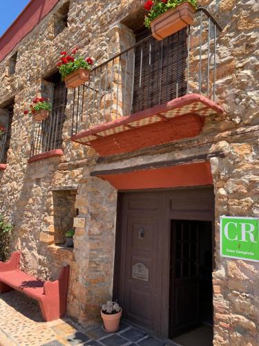 a stone building with a door and a bench in front of it at CASA RURAL VICENTA 1750 in Albentosa