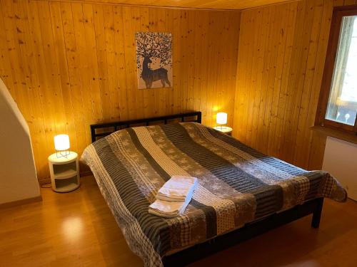 a bedroom with a bed and two lights on two tables at California House in Klosters