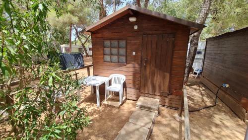 a small wooden shed with a table and a chair at Camping Villaggio Egad in Favignana