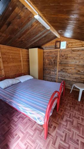 a bed in a room with a wooden ceiling at Camping Villaggio Egad in Favignana