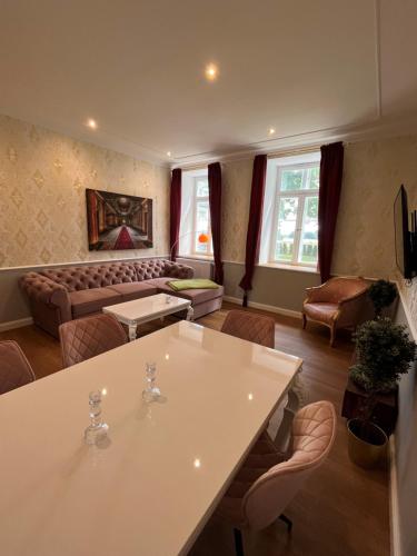 ein Wohnzimmer mit einem Sofa, einem Tisch und Stühlen in der Unterkunft Herrenhaus-Henriettenhof in Grömitz