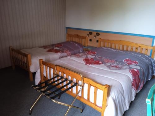 two twin beds in a room with at Hotel Restaurant Le Traineau in Clelles