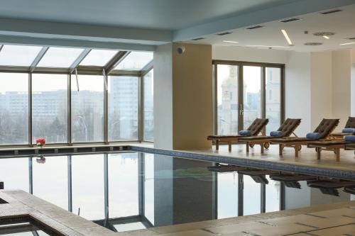 una piscina con sedie in un edificio di Hotel International Iasi a Iaşi