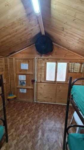 a cabin with wooden walls and a ceiling with windows at Camping Villaggio Egad in Favignana
