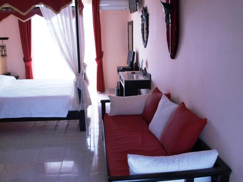 a living room with a couch and a bed at Castello Di Cavallieri Suites & Spa - Adults Only in Faliraki