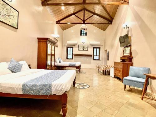 a bedroom with a bed and a tv in a room at Hotel Mount View Heritage in Panchgani