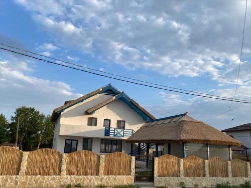 a house with a fence in front of it at Casa Munteanu in Mila Douăzeci şi Trei