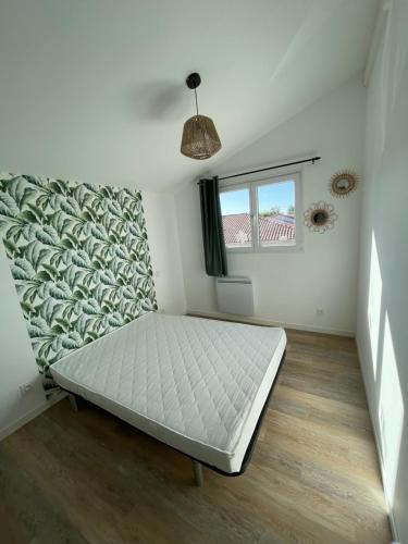 een slaapkamer met een bed in een kamer met een raam bij La grange in Saint-Laurent-sur-Sèvre