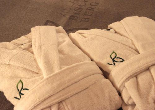 a white towel with green plants on it at Villa Bischofsberg - Lärchen-Wellness Apartment in Windischgarsten