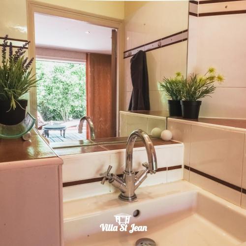 a kitchen sink with a large mirror above it at La Villa Saint Jean BAS DE VILLA in La Ciotat