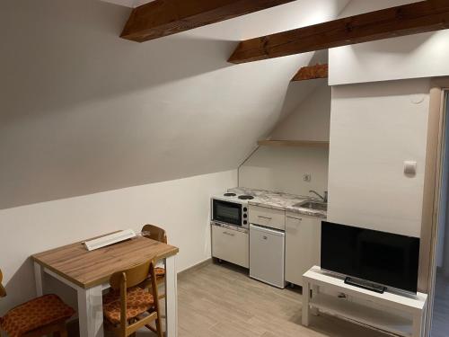 een kleine keuken met een tafel en een televisie bij Banja Vrujci in Mionica
