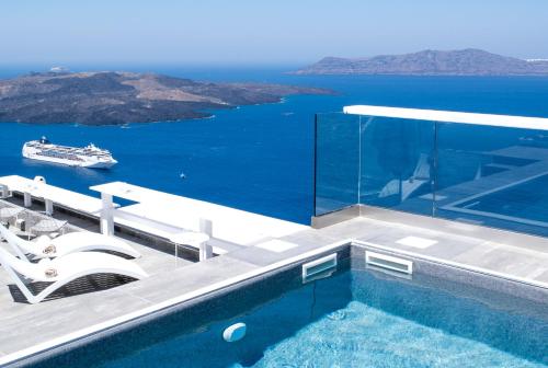 a swimming pool with a cruise ship in the water at Hotel Thireas in Fira