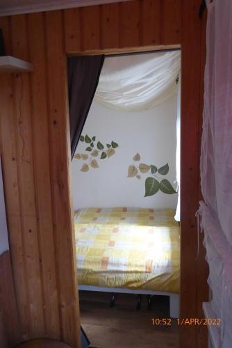ein kleines Bett in einem Zimmer mit Vorhang in der Unterkunft Bungalow nebst Wohnwagen für 4 bis 5 Personen in Nähe von See- und Tesla 