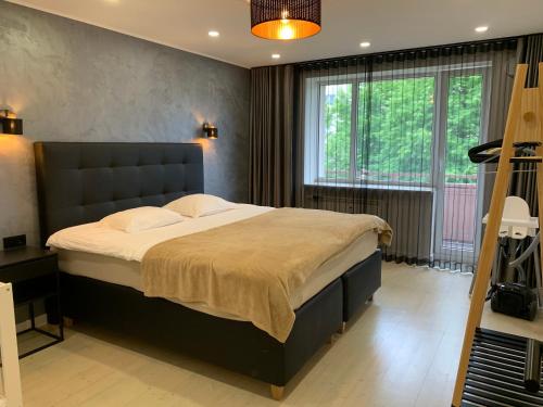 1 dormitorio con cama grande y ventana grande en Tammsaare Luxury Apartment en Pärnu