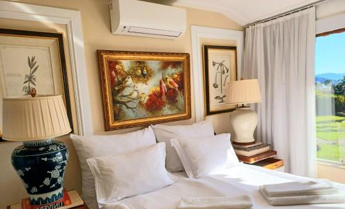 sypialnia z białym łóżkiem z obrazami na ścianie w obiekcie Frente & Vista do Mar - Fasano Area, Porto Frade - Angra dos Reis, RJ Seafront View - Inside a Condo - Next to a 5-Star Hotel w mieście Angra dos Reis