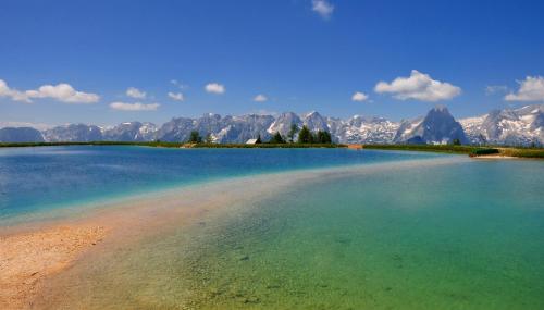 a large body of water with mountains in the background at Villa Bischofsberg - Lärchen-Wellness Apartment in Windischgarsten