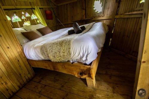 a bedroom with a bed in a wooden room at Le Petit Moulin du Rouvre in Saint-Pierre-de-Plesguen