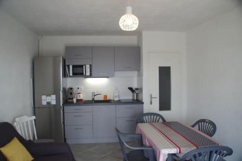 een keuken met een tafel en een keuken met een koelkast bij Superbe appartement avec vue sur le port et plage in Saint Pierre La Mer