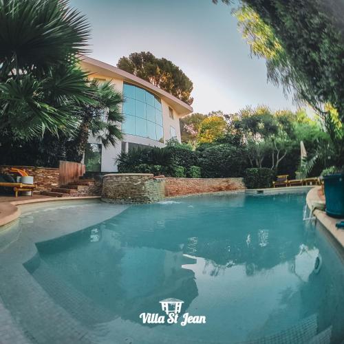 a swimming pool in front of a house at La Villa Saint Jean BAS DE VILLA in La Ciotat