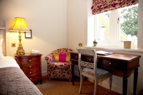 a bedroom with a desk and a chair and a window at Whitley Hall Hotel in Chapeltown