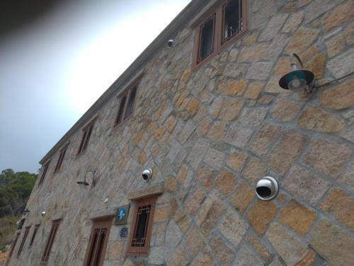 a stone building with windows and a camera on it at mei hao min su in Nangan