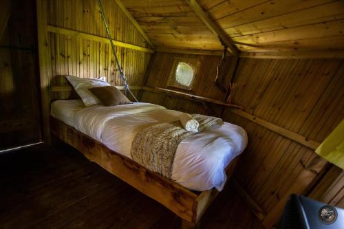 Ce lit se trouve dans un chalet en bois. dans l'établissement Le Petit Moulin du Rouvre, à Saint-Pierre-de-Plesguen