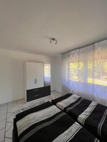 a bedroom with two beds and a large window at Ferienwohnung zum Schauinslandweg in Neunkirchen