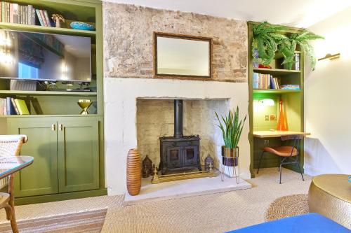 a living room with a fireplace and green shelves at Cinnabar Romantic Hideaway on Historic Walls in Berwick-Upon-Tweed
