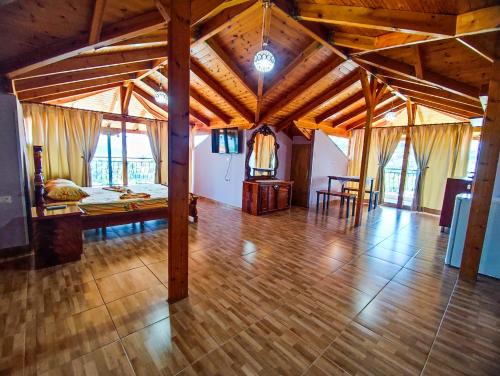 a large room with a bed and a wooden floor at Lovely 1 - bedroom loft with free parking in Gjirokastër