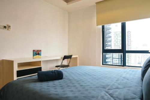 a bedroom with a bed and a desk and a chair at Casa Residency Apartment in Kuala Lumpur
