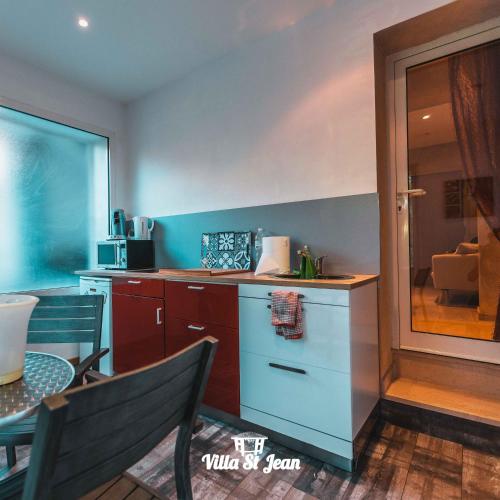 a kitchen with a counter and a table and a table and chairs at La Villa Saint Jean BAS DE VILLA in La Ciotat