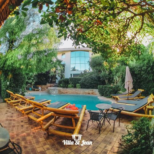 a swimming pool with lounge chairs and a table at La Villa Saint Jean BAS DE VILLA in La Ciotat