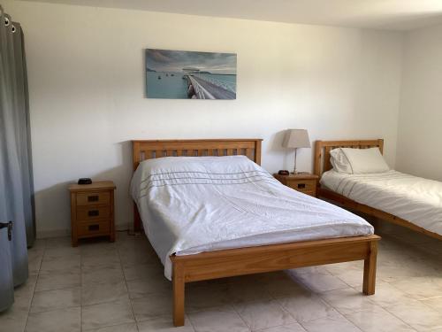 une chambre avec deux lits et un tableau au mur dans l'établissement 2 bedroom ground floor modern apartment 4km beach, à Villelongue-de-la-Salanque