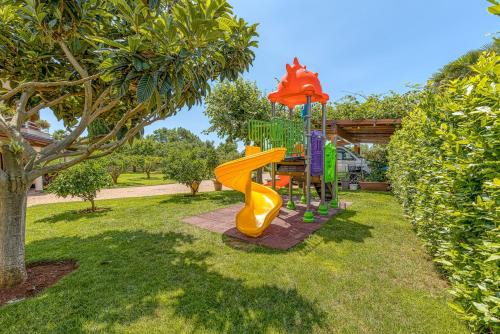 a playground with a slide in a yard at Apartment Complex Irena with Pool in Poreč