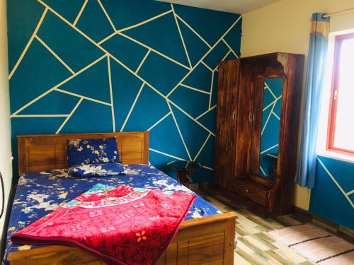 a bedroom with a bed and a blue wall at Coorg West End Home Stay in Madikeri