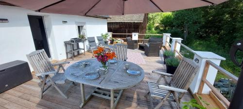 una mesa y sillas en una terraza con sombrilla en Ferienwohnungen Marienweiher, en Marktleugast